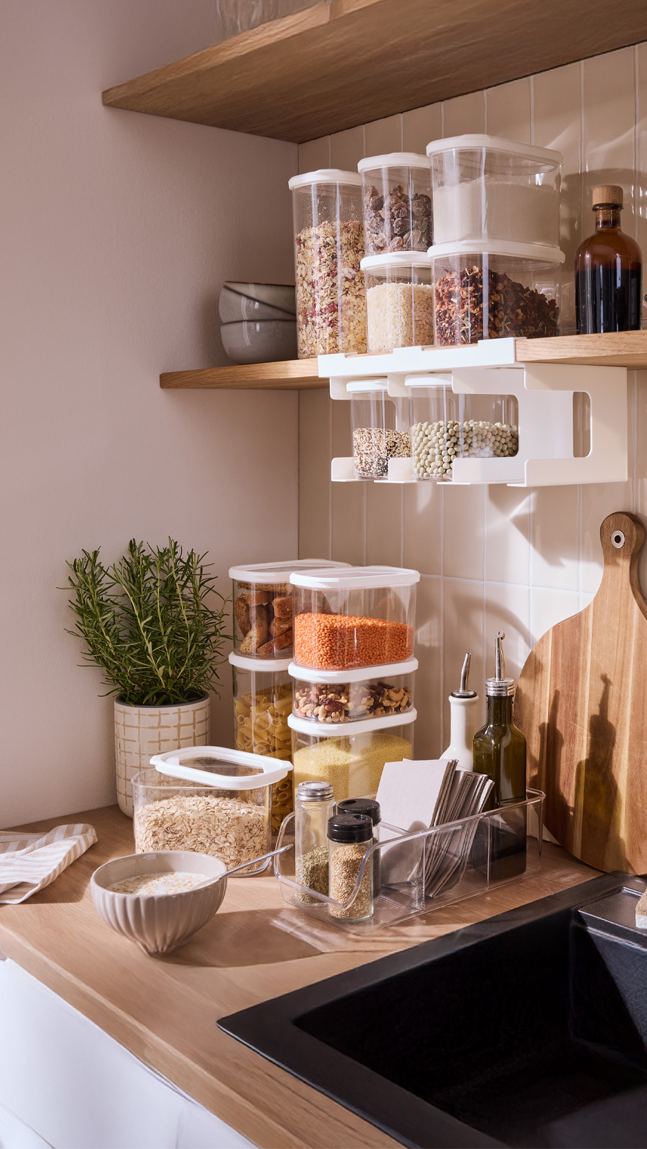 Bucătărie organizată cu recipiente de depozitare, condimente și plante aromatice.