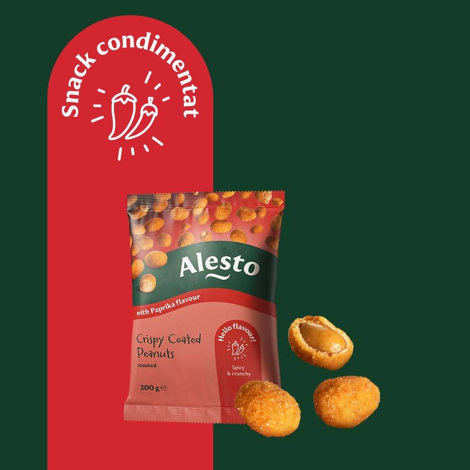 O pungă de arahide crocante cu aromă de paprika, cu trei arahide lângă, pe un fundal roșu și verde.