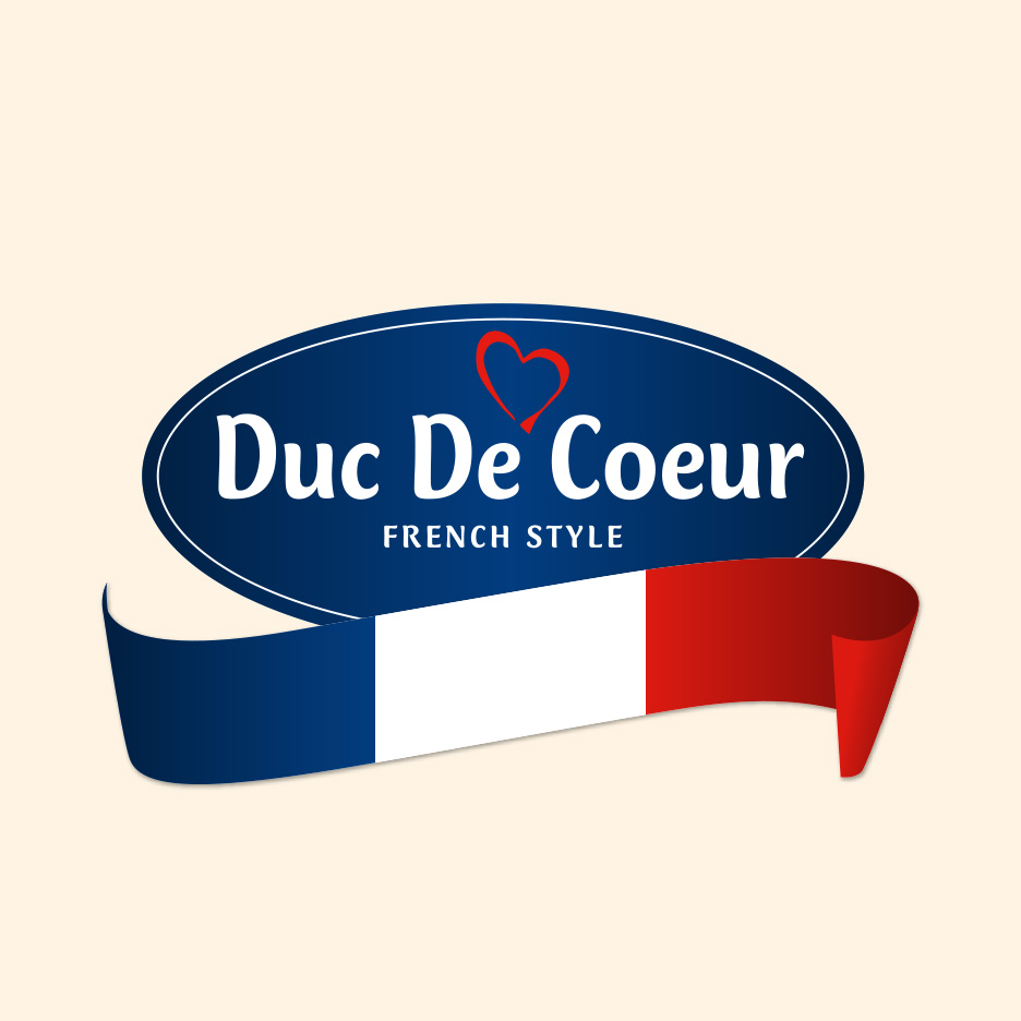 Siglă ovală albastră cu text alb „Duc De Coeur FRENCH STYLE” și o panglică în culorile drapelului francez.