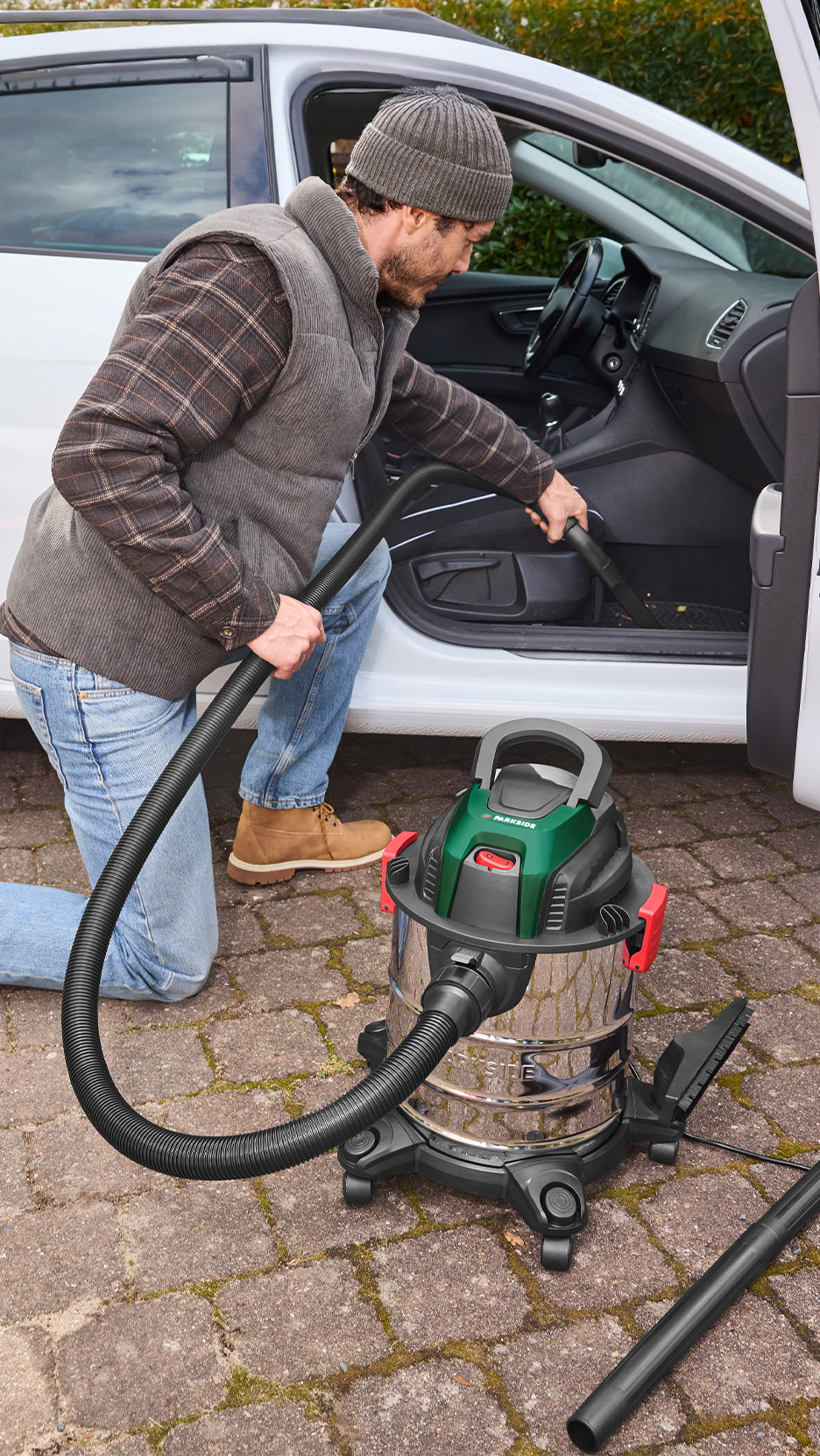 Bărbat curățând interiorul mașinii cu un aspirator umed/uscat Parkside.