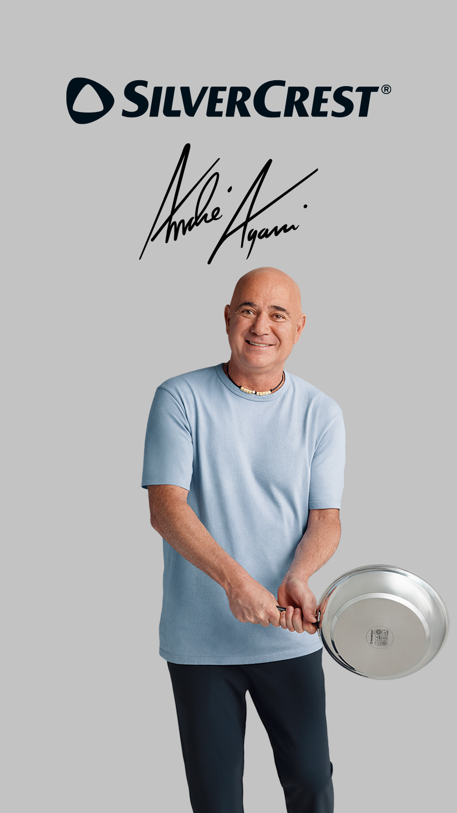 Andre Agassi, într-un tricou albastru, ținând o tigaie de inox, cu o semnătură deasupra.