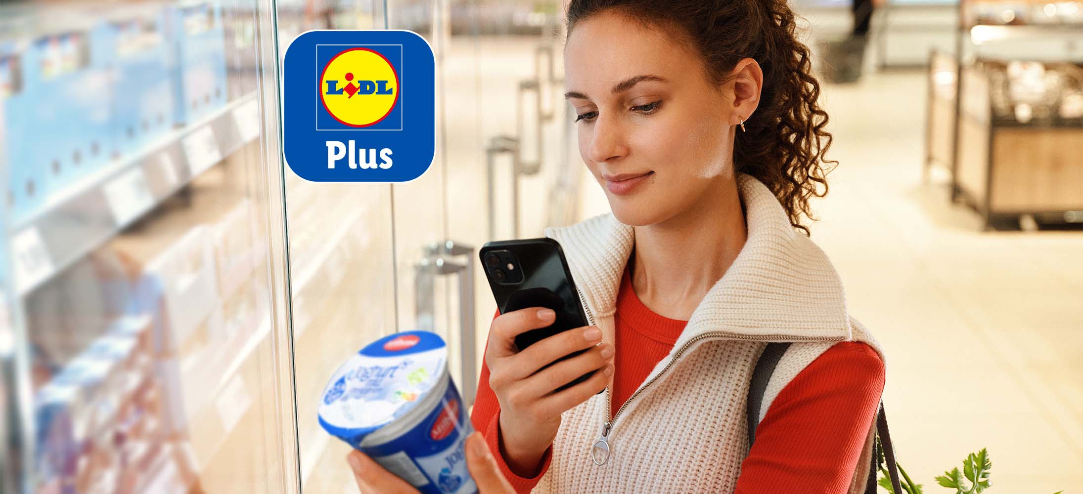 O femeie scanează un iaurt cu aplicația Lidl Plus într-un magazin Lidl.