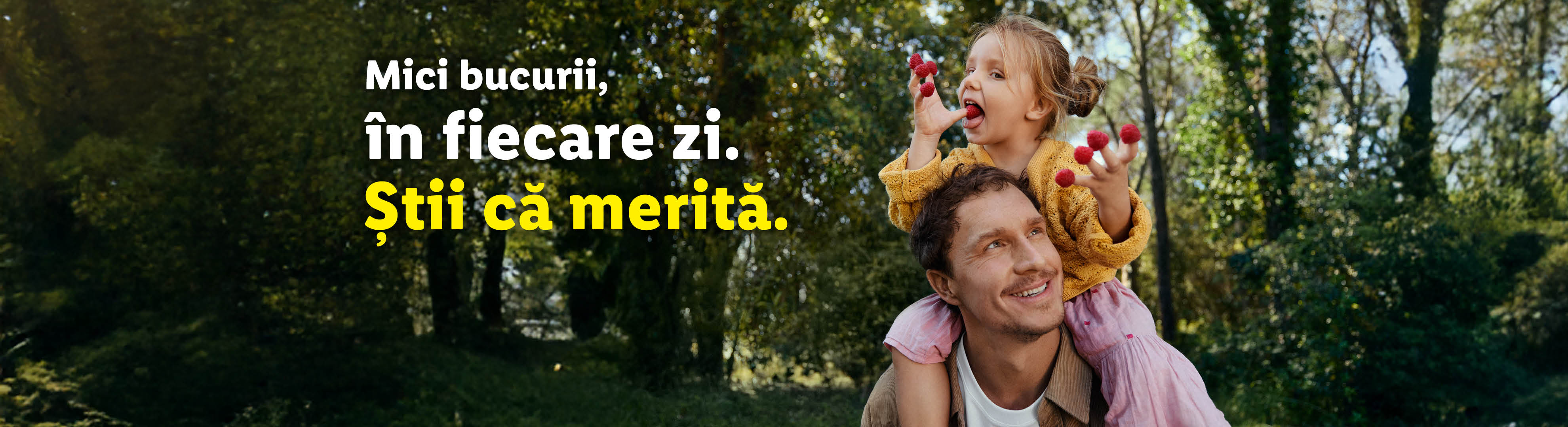 Un tată și fiica sa zâmbesc, fata stând pe umerii tatălui și mâncând zmeură.